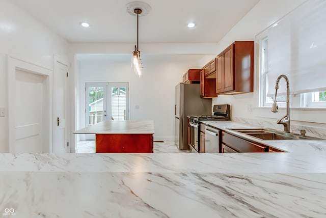 kitchen featuring a wealth of natural light, sink, decorative light fixtures, and stainless steel appliances