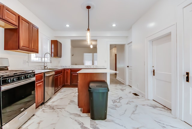 kitchen featuring sink, a center island, appliances with stainless steel finishes, and decorative light fixtures