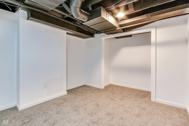 basement featuring light carpet