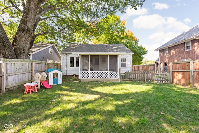 rear view of property with a yard and a sunroom