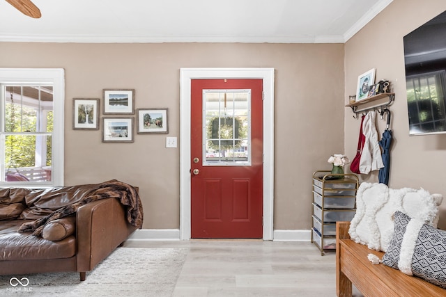 entryway with light hardwood / wood-style floors, ornamental molding, and ceiling fan