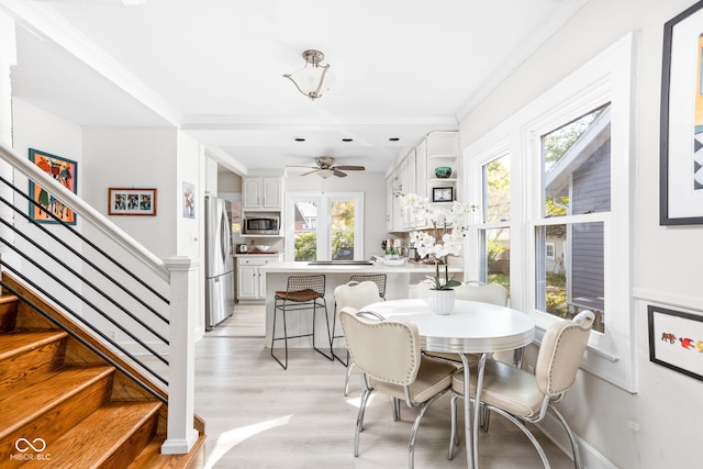 dining space with ornamental molding, light wood-type flooring, and ceiling fan