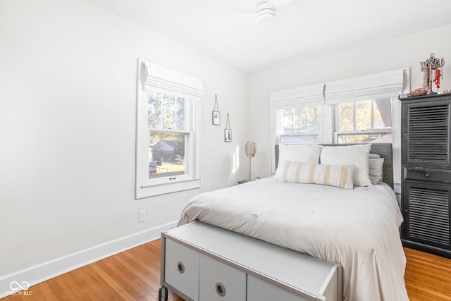 bedroom featuring light hardwood / wood-style floors, multiple windows, and ceiling fan