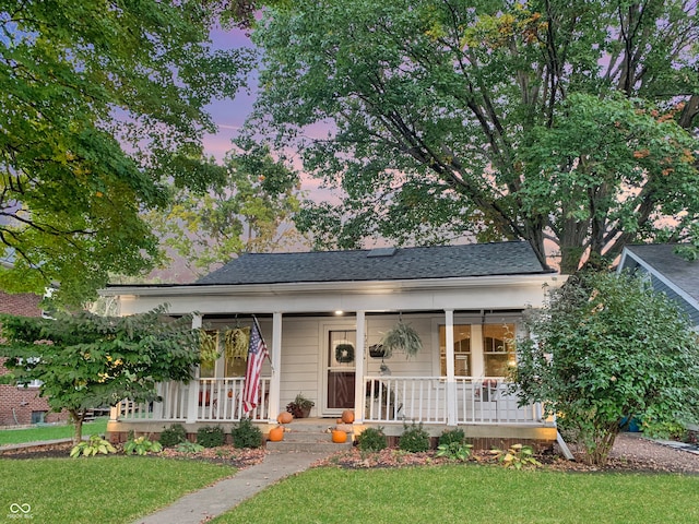 view of front of house with covered porch and a lawn