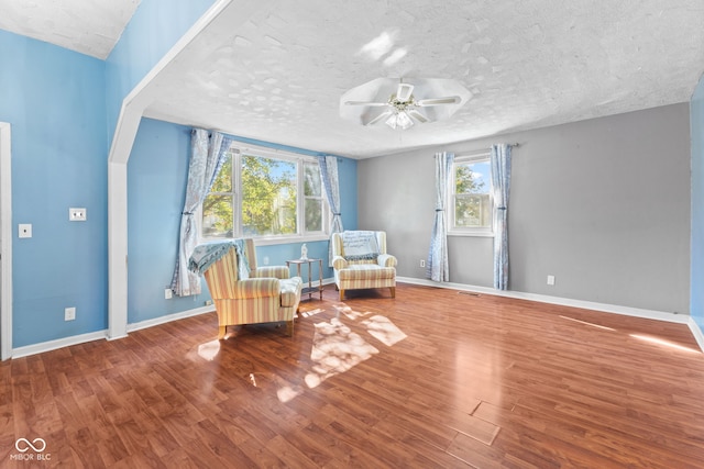 unfurnished room with a textured ceiling, wood-type flooring, and ceiling fan