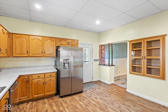 kitchen with a drop ceiling, stainless steel appliances, and light wood-type flooring