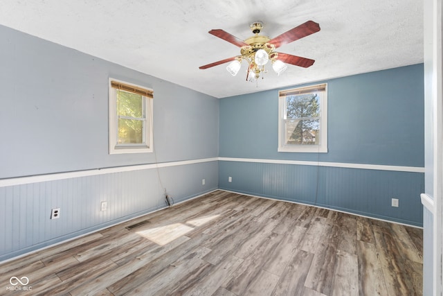 spare room featuring hardwood / wood-style floors and plenty of natural light