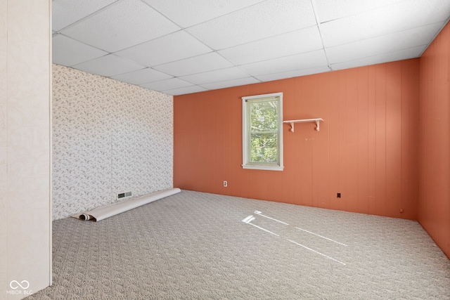 spare room featuring a paneled ceiling and carpet flooring