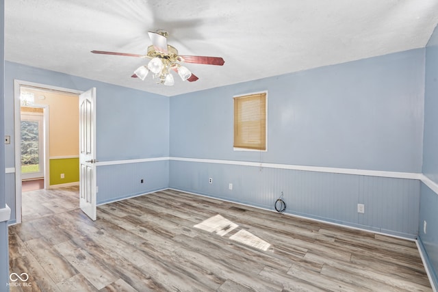 spare room featuring light hardwood / wood-style flooring, a textured ceiling, and ceiling fan