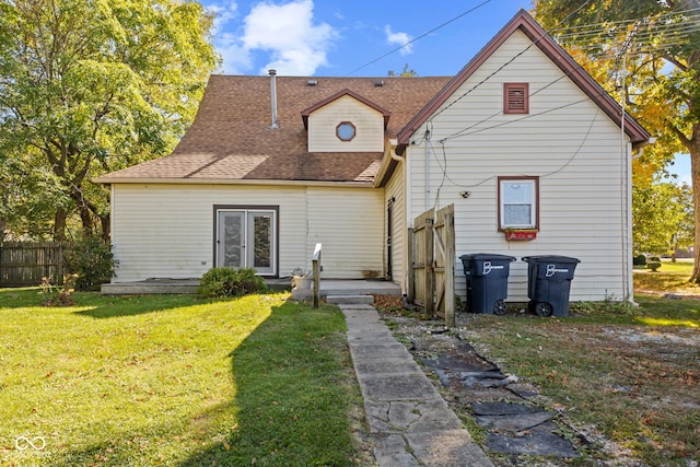 rear view of house featuring a lawn