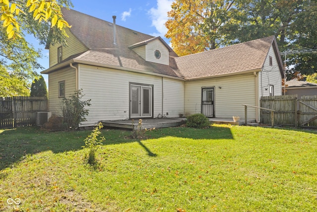 back of property featuring cooling unit, a deck, and a lawn