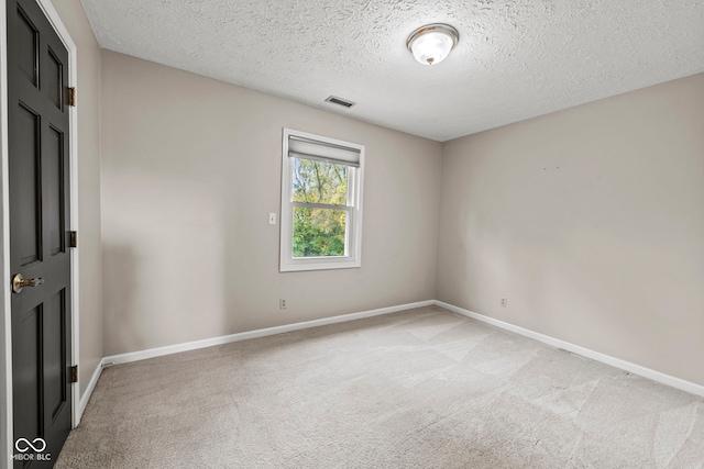 carpeted empty room with a textured ceiling