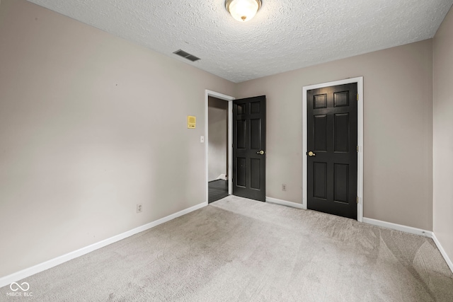 unfurnished bedroom with carpet and a textured ceiling