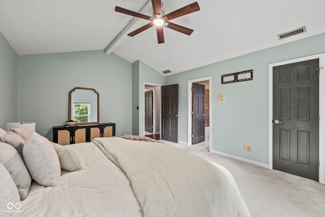 carpeted bedroom with ensuite bath, lofted ceiling with beams, and ceiling fan