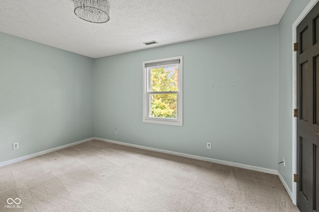 carpeted spare room featuring a textured ceiling