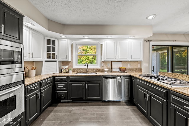 kitchen with white cabinets, a healthy amount of sunlight, sink, and stainless steel appliances