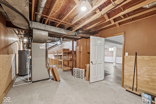 basement featuring heating unit and water heater