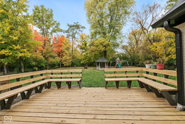 wooden deck featuring a yard, a gazebo, and a playground