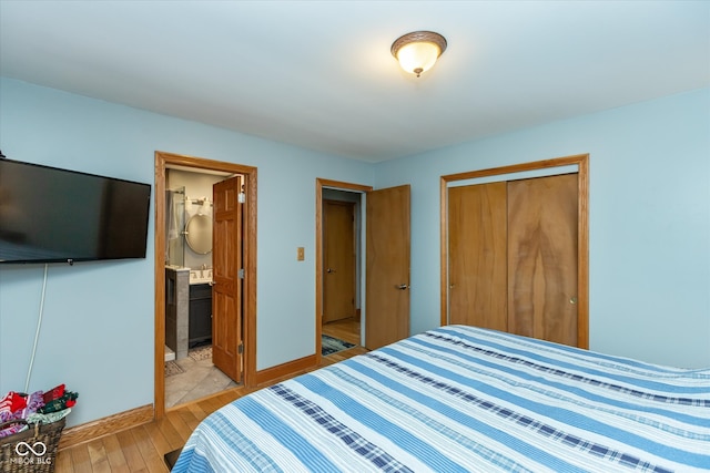 bedroom featuring a closet, ensuite bathroom, and light wood-type flooring