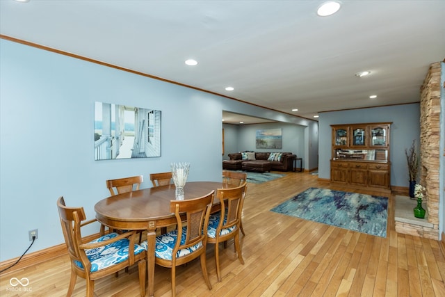 dining area with light hardwood / wood-style flooring and crown molding