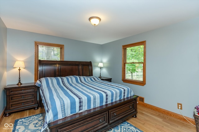 bedroom featuring light hardwood / wood-style flooring and multiple windows