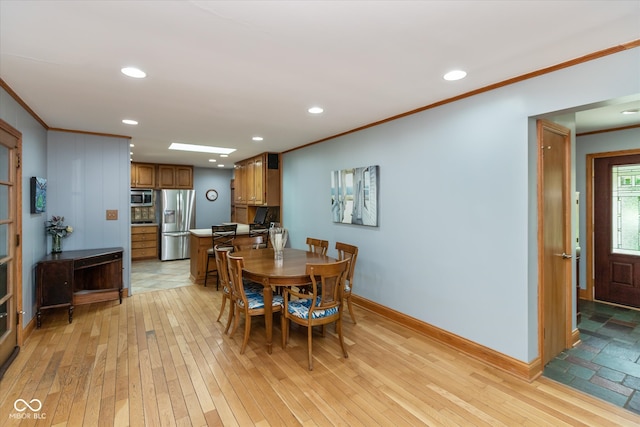 dining space featuring ornamental molding and light wood-type flooring