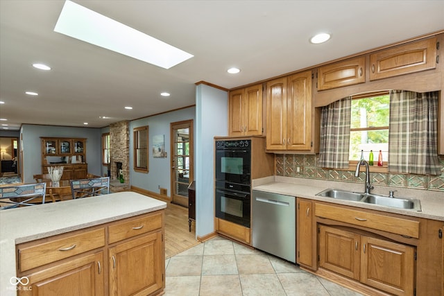 kitchen with tasteful backsplash, stainless steel dishwasher, light hardwood / wood-style flooring, double oven, and sink