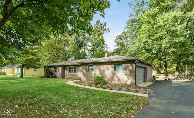 ranch-style house featuring a front lawn and a garage