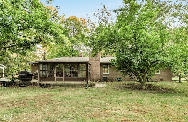 back of property featuring central AC, a yard, and a sunroom