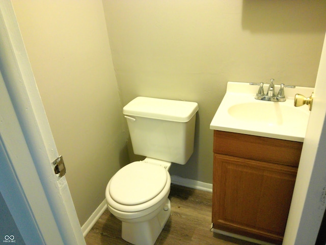 bathroom featuring vanity, hardwood / wood-style flooring, and toilet