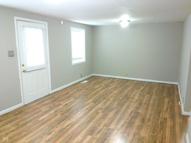 unfurnished room with dark wood-type flooring