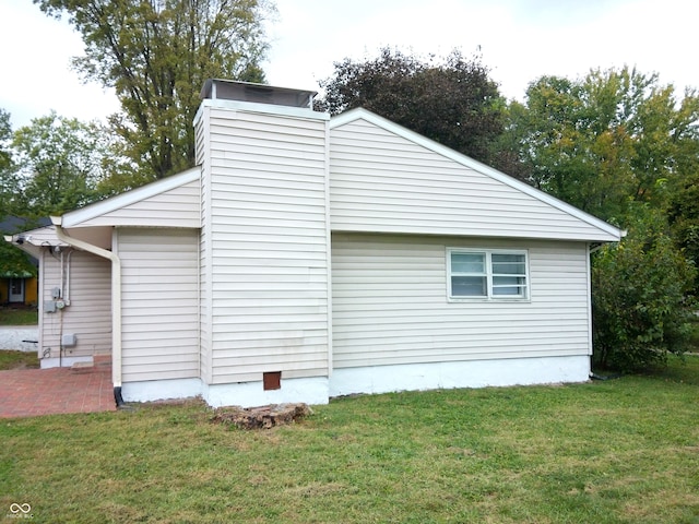 view of side of home with a patio and a yard