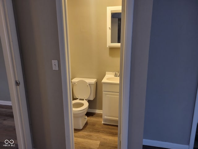 bathroom featuring hardwood / wood-style flooring, vanity, and toilet