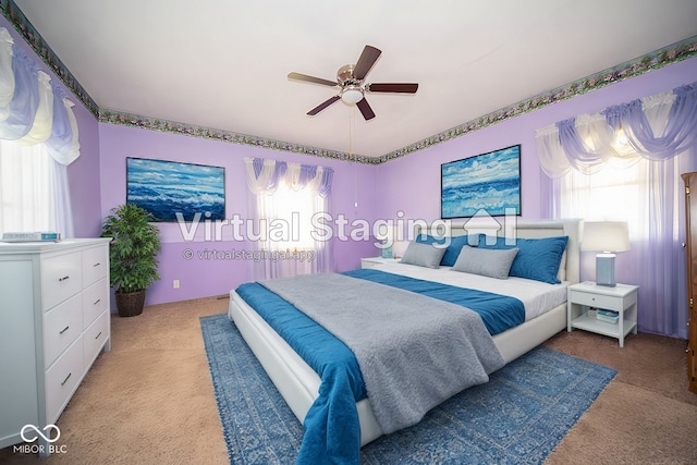 carpeted bedroom with ceiling fan and multiple windows