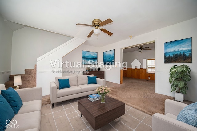 living room with wooden walls, light colored carpet, and ceiling fan