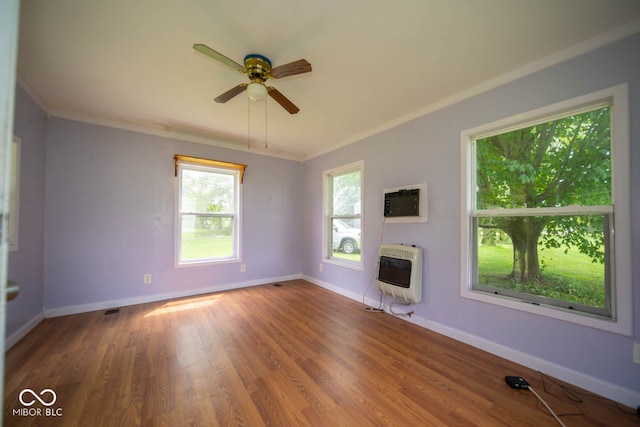 unfurnished living room with ornamental molding, wood-type flooring, heating unit, and ceiling fan