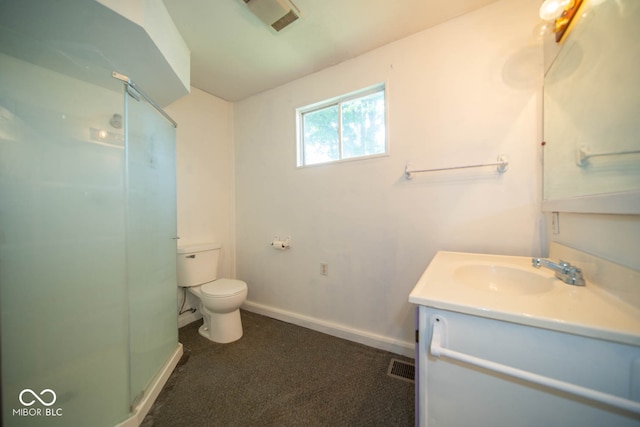 bathroom with vanity, toilet, and a shower with door