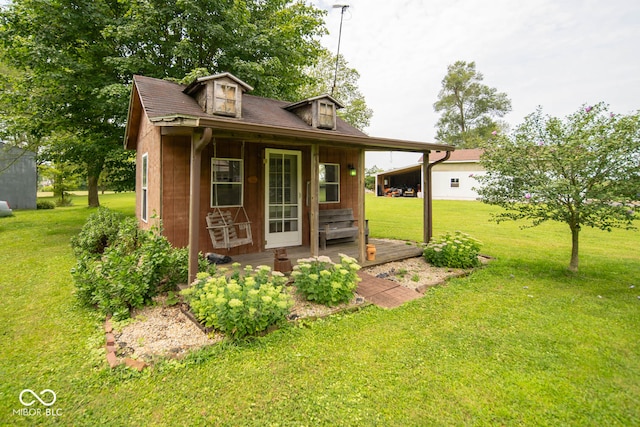 view of outbuilding with a porch and a yard