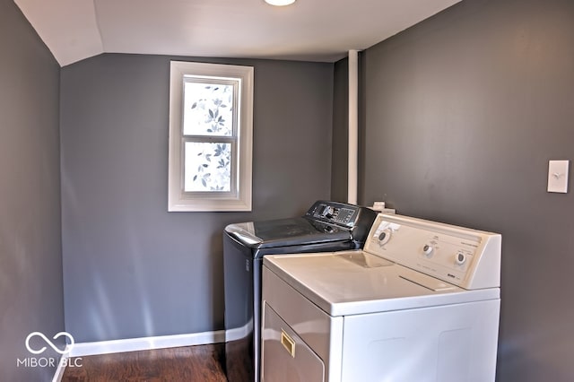 clothes washing area featuring washer and dryer and dark wood-type flooring