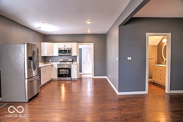 kitchen featuring sink, white cabinetry, stainless steel appliances, and dark hardwood / wood-style floors