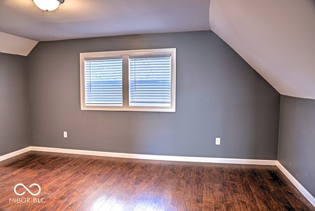 additional living space featuring vaulted ceiling and dark hardwood / wood-style flooring