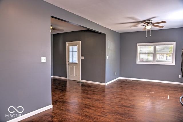 unfurnished room featuring ceiling fan, a wealth of natural light, and dark hardwood / wood-style flooring