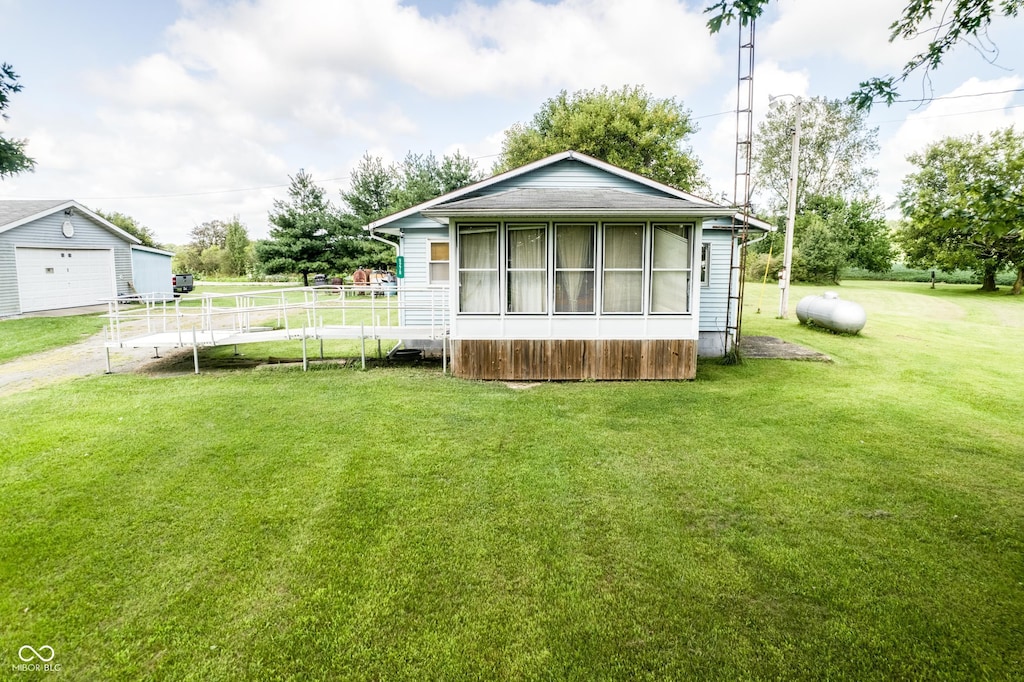 exterior space with an outbuilding, a garage, and a lawn