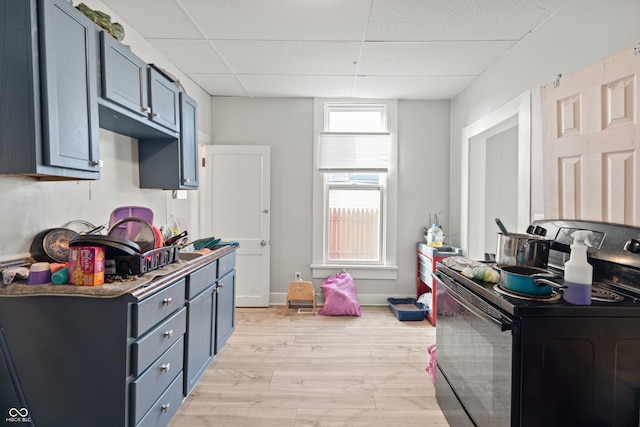 kitchen with black range with electric cooktop, a drop ceiling, and light hardwood / wood-style floors