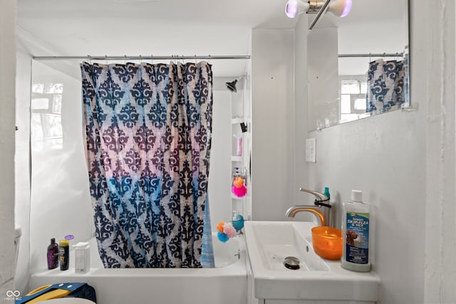 bathroom featuring shower / tub combo with curtain and sink