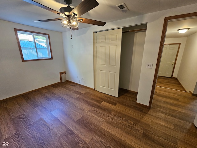 unfurnished bedroom featuring ceiling fan, a closet, and dark wood-type flooring