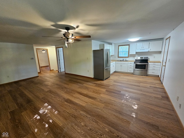 kitchen with sink, ceiling fan, appliances with stainless steel finishes, white cabinetry, and wood-type flooring