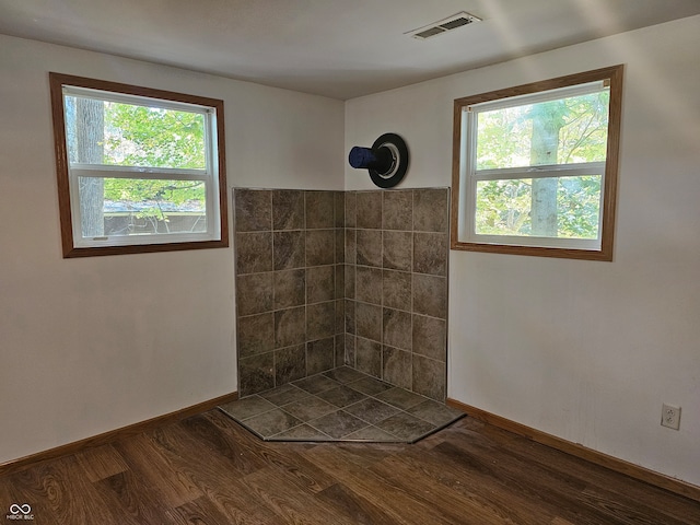 bathroom with a shower, hardwood / wood-style floors, and a healthy amount of sunlight