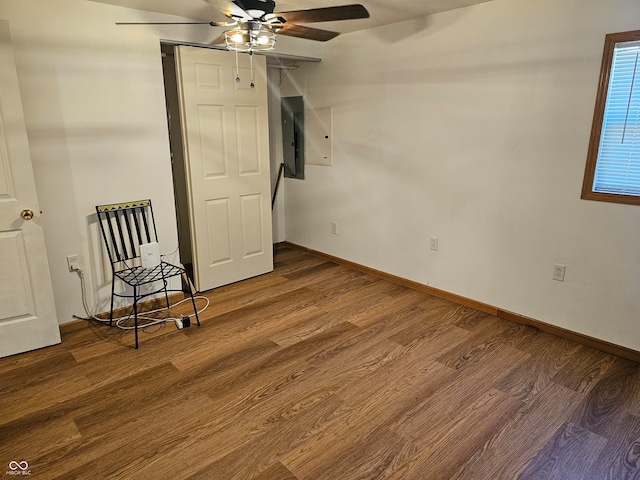 interior space featuring wood-type flooring, electric panel, and ceiling fan