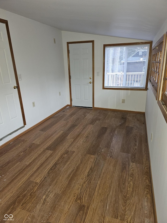 interior space with dark wood-type flooring and vaulted ceiling